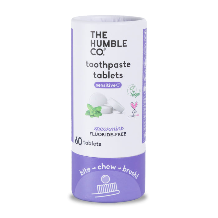 A cylindrical container of The Humble Co. sensitive toothpaste tablets, spearmint flavor, featuring vegan and cruelty-free labels. The package contains 60 fluoride-free tablets and the instructions bite → chew → brush!.