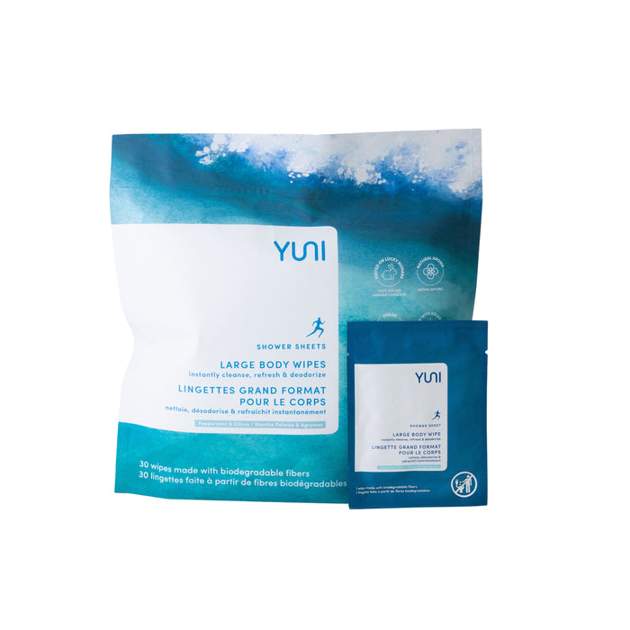A package of YUNI Shower Sheets large body wipes with one individual wipe packet in front. The packaging is blue and white with text in English and French and contains 30 wipes made from biodegradable fibers.
