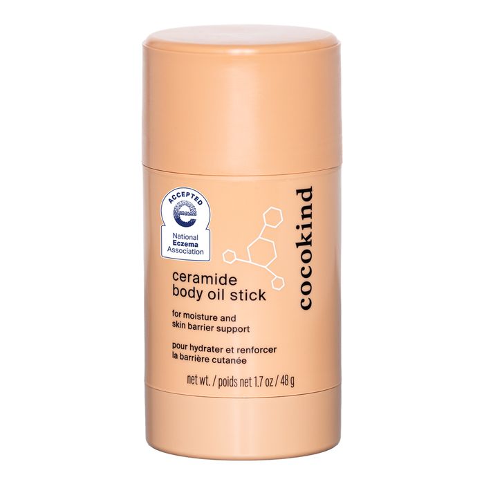 A tan cylindrical container labeled ceramide body oil stick by Cocokind, designed for moisture and skin barrier support, with the National Eczema Association acceptance seal on the front.