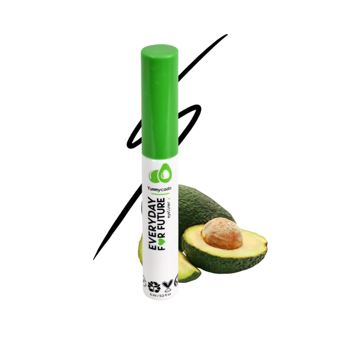 A white tube with a green cap labeled EVERYDAY FOR FUTURE stands in front of a halved avocado, with a black curved line in the background. The packaging features avocado graphics and eco-friendly symbols.