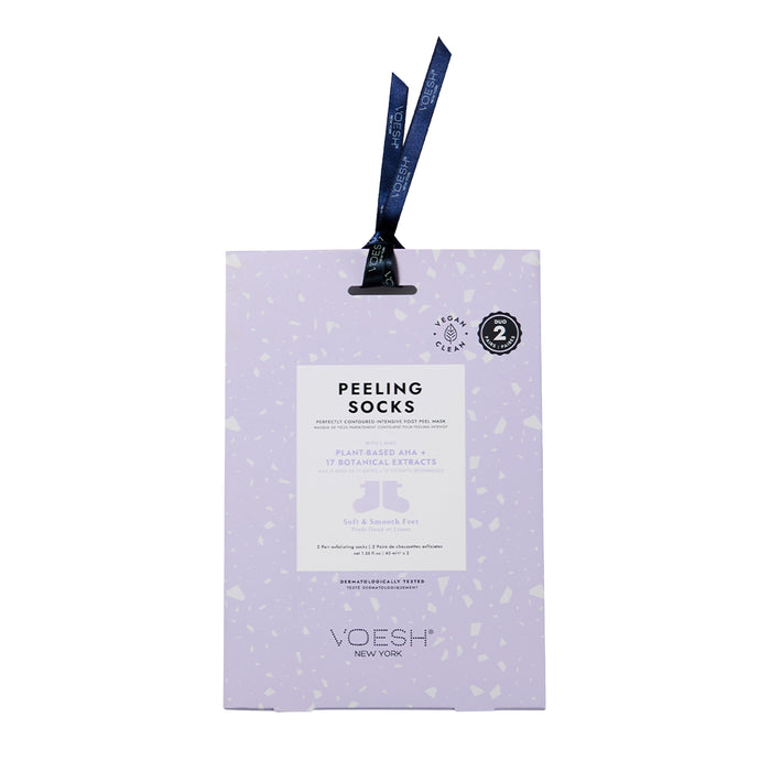 A lavender-colored package of Voesh New York Peeling Socks, featuring a hanging blue ribbon, product details in white text, and a round 100% vegan label in the top right corner.