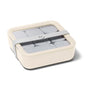 A cream-colored, rectangular food container with a clear lid, gray interior dividers, and a gray elastic band securing the lid.
