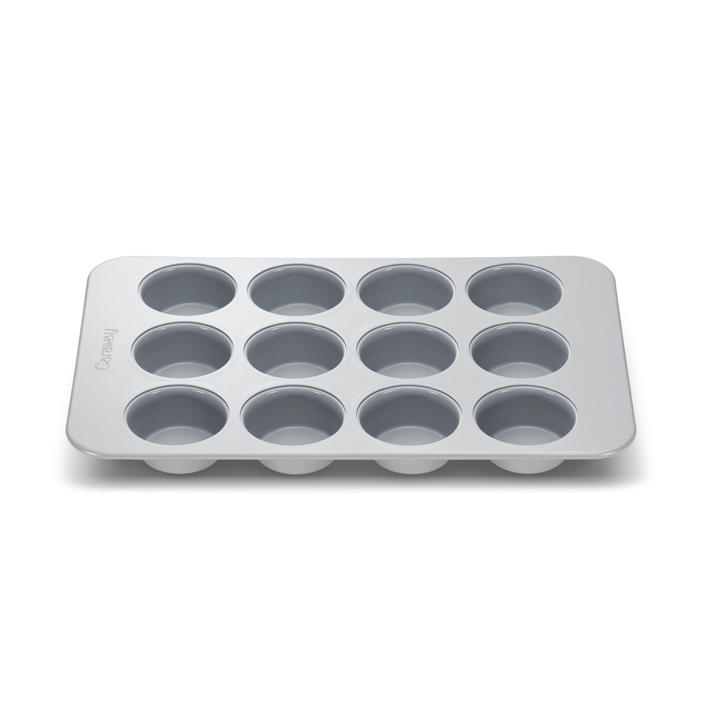 The Caraway Muffin Pan, a metal 12-cup rectangular pan with a non-stick surface, is perfect for baking cupcakes or muffins. It features evenly spaced circular cups for consistent results, all showcased on a simple white background.