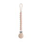 The mushie Silicone Pacifier Clip | Hera in beige is made from food-grade silicone with round beads, a top loop for pacifier attachment, and a metal clip to secure to clothing—an essential for your baby essentials.
