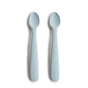 Two mushie Silicone Feeding Spoons, made from BPA-free, food-grade material, in light blue with rounded tips, lie side by side on a white background. “mushie” is embossed on the handles—perfect essentials for baby mealtime.