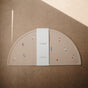 The mushie Silicone Placemat – 100% Food Grade Silicone is a beige, semicircular mat with colorful rocket designs, packaged with a white band labeled mushie—perfect for baby essentials.