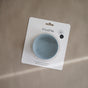The mushie Silicone Suction Bowl, made of BPA-free, food-grade silicone, rests in its white packaging on a beige surface—a must-have among baby essentials.