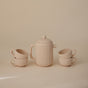 The mushie Silicone Tea Play Set – Pretend Play, BPA-Free, features a beige teapot with lid and matching cups, arranged against a neutral background—ideal for imaginative play or pairing with other food-grade silicone sets.