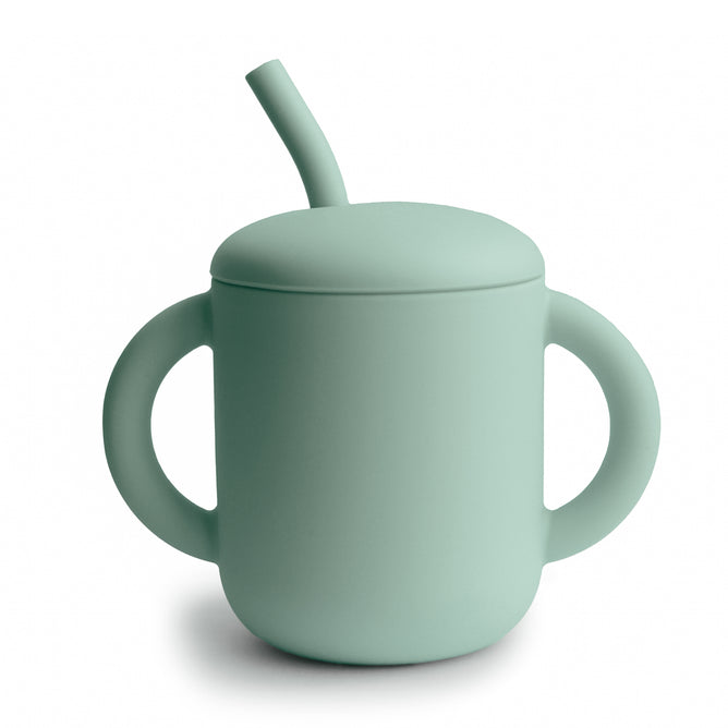 The mushie Silicone Training Cup with Straw is BPA-free, easy to hold with two large handles, and comes in light green food grade silicone with a matching angled straw lid—an ideal addition to your baby essentials.