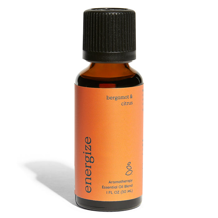 A small amber glass bottle with a black cap, labeled “energize” in lowercase letters. The orange label indicates it’s a bergamot & citrus aromatherapy essential oil blend, containing 1 fl oz (30 ml).