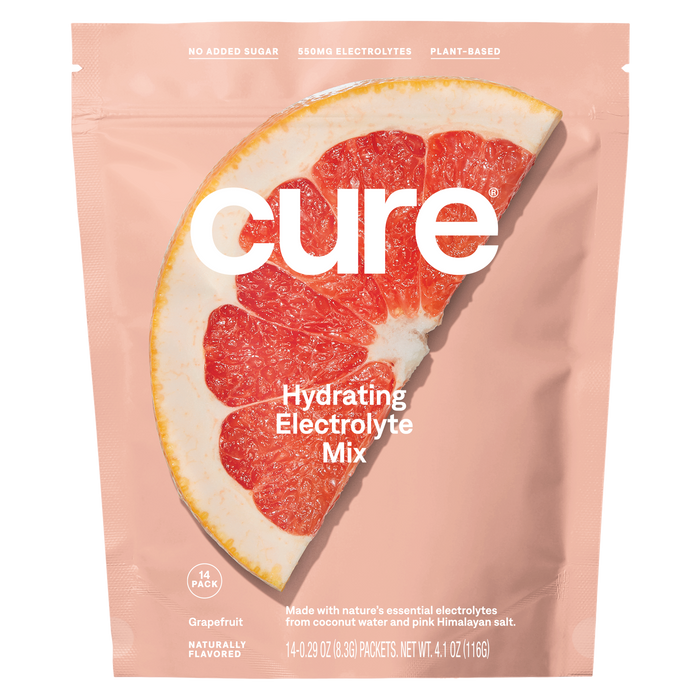 A pink package of Cure Hydrating Electrolyte Mix featuring a large grapefruit slice. The packaging highlights no added sugar, 550mg electrolytes, plant-based, and naturally flavored grapefruit.