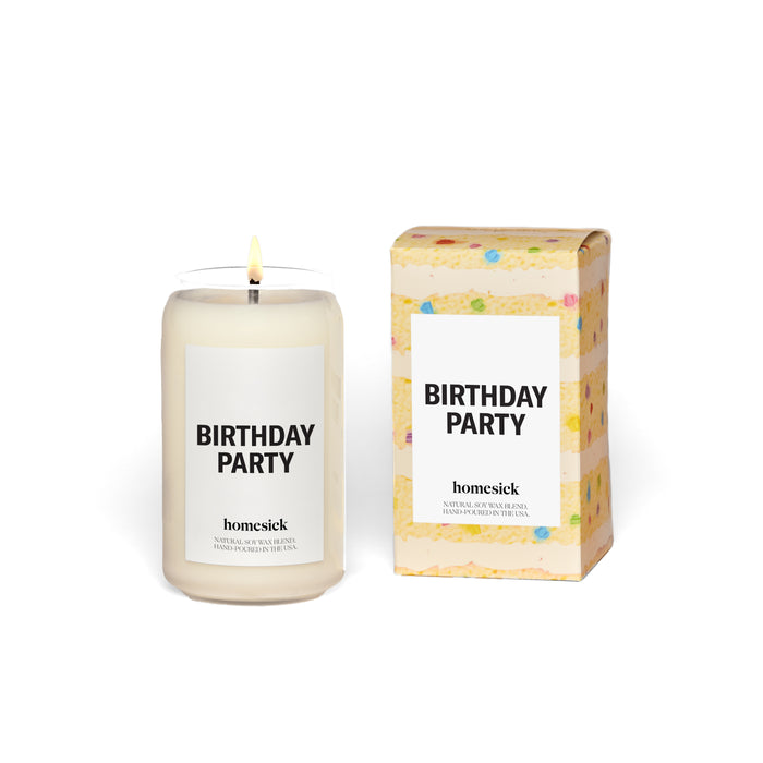 A white candle labeled Birthday Party sits next to a matching box decorated like a slice of birthday cake with colorful sprinkles. Both items are from the brand Homesick.
