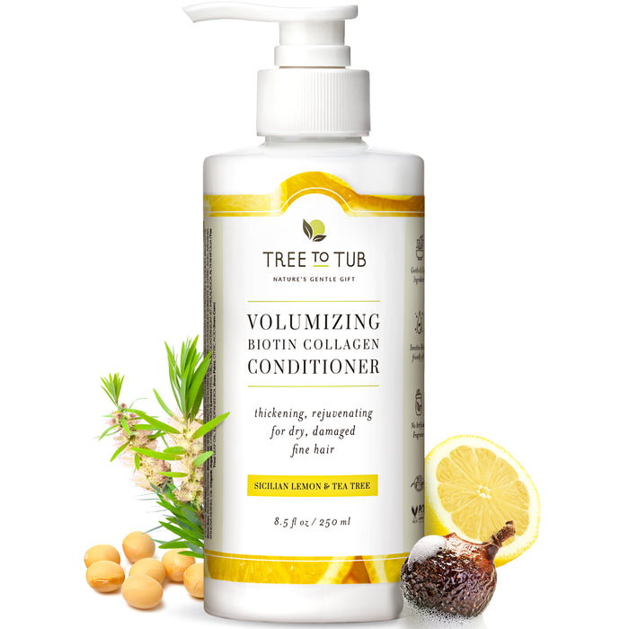 A bottle of Tree to Tub Volumizing Biotin Collagen Conditioner with a pump top, surrounded by soybeans, tea tree leaves, a lemon slice, and a soapberry. The label lists Sicilian lemon and tea tree as ingredients.