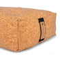 A close-up of the Yoloha Yoga Cork Bolster, a rectangular bolster made from sustainable cork, featuring a lightweight cushioned feel and a fabric handle on the side adorned with a small branded tag.