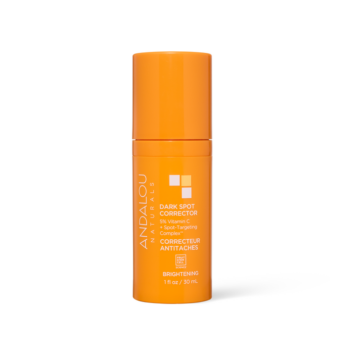 A bright orange cylindrical bottle of Andalou Naturals Brightening Dark Spot Corrector, featuring a front label with white text outlining key ingredients: 5% Vitamin C and Non-Spot Targeting Complex for hyperpigmentation. The bottle contains 1 fl oz (30 ml).