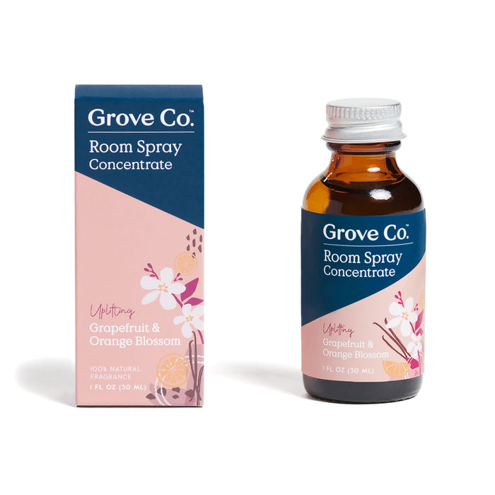 A bottle and box of Grove Co. Room Spray Concentrate in Grapefruit & Orange Blossom scent. The packaging is pink and blue with floral and citrus illustrations, displaying product details and a 1 fl oz (30 mL) label.