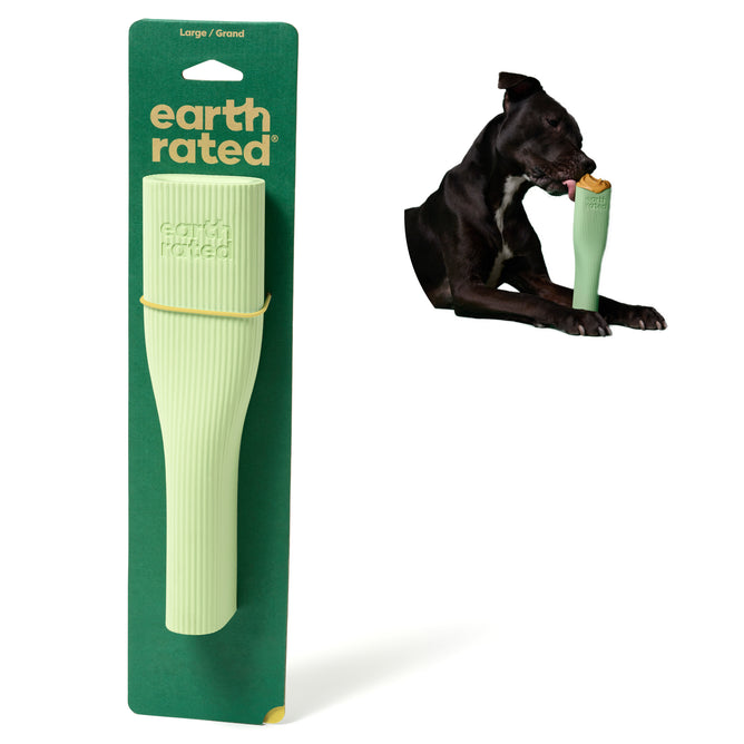 Earth Rateds Natural Rubber Dog Enrichment Toy packaging is shown beside a dark-colored dog holding the toy in its mouth. This textured, ergonomic toy is crafted from natural rubber for canine play, ensuring endless fun and comfort.