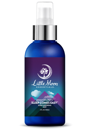 A blue spray bottle labeled Little Moon Essentials Aromatherapeutic Sleep Comes Easy Sleep-Inspiring Mist with a white tree logo, mountains, and a crescent moon on the label.
