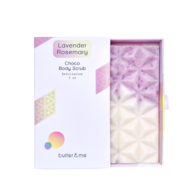A box of butter & me Choco Body Scrub in Lavender Rosemary scent, partially open to show the geometric, purple and white exfoliating scrub inside. The packaging features pastel geometric designs.