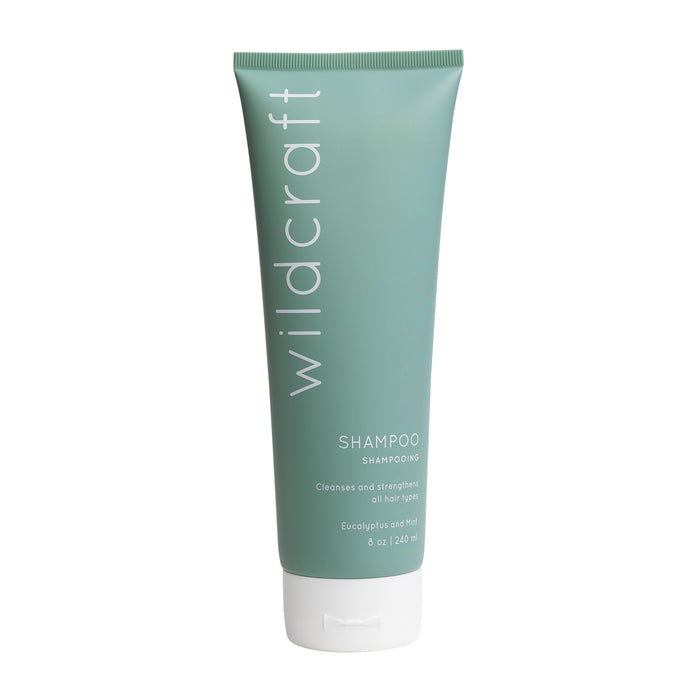 A green tube of Wildcraft shampoo with white text, labeled as cleansing and strengthening for all hair types, eucalyptus and mint scent, 8 oz / 240 ml.