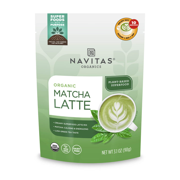 A green and white pouch of Navitas Organics Organic Matcha Latte mix, displaying a cup of green matcha latte with a leaf design, and various labels including USDA Organic, Non-GMO, and Dairy Free.