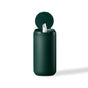 A dark green cylindrical container with a flip-top lid, slightly open to reveal a single white wipe being dispensed, set against a plain white background.