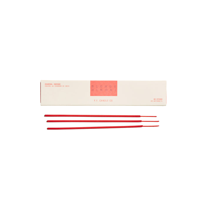 A cream-colored box labeled PF Candle Co. Incense with red text is displayed above four red incense sticks placed in a row on a white background.