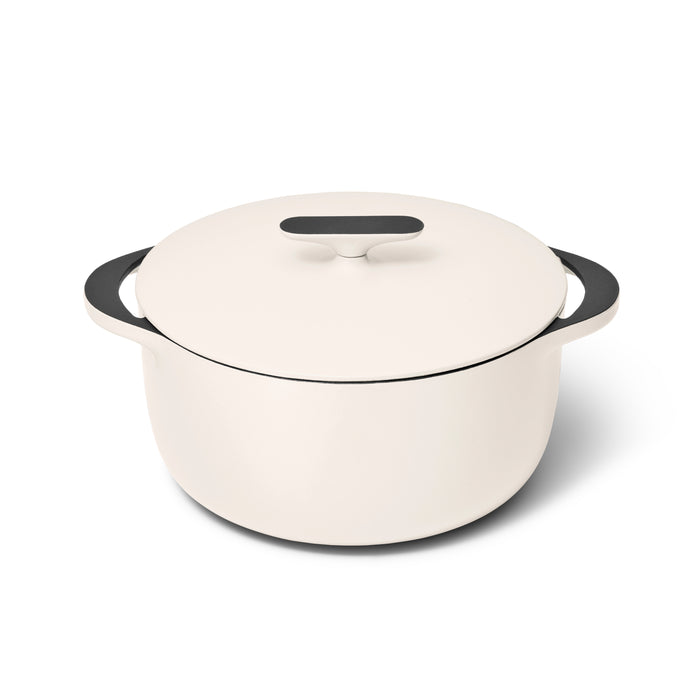 A white, round Dutch oven with a matching lid and black handles, placed on a white background.