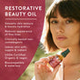 A woman holds a bottle of Badger Balm’s Rose Beauty Oil – Restores & Smooths, next to a list highlighting its benefits: infused with organic rose oil for hydration, reduced fine lines, non-comedogenic formula, organic ingredients, vegan-friendly, and biocompatible properties.