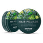 Two 56g/2oz tins of Badger Balm Organic Hair Pomade Tin – Style & Shine, featuring green leafy and citrus artwork on the lids. Labels indicate 85% organic ingredients and medium hold for natural style and shine.