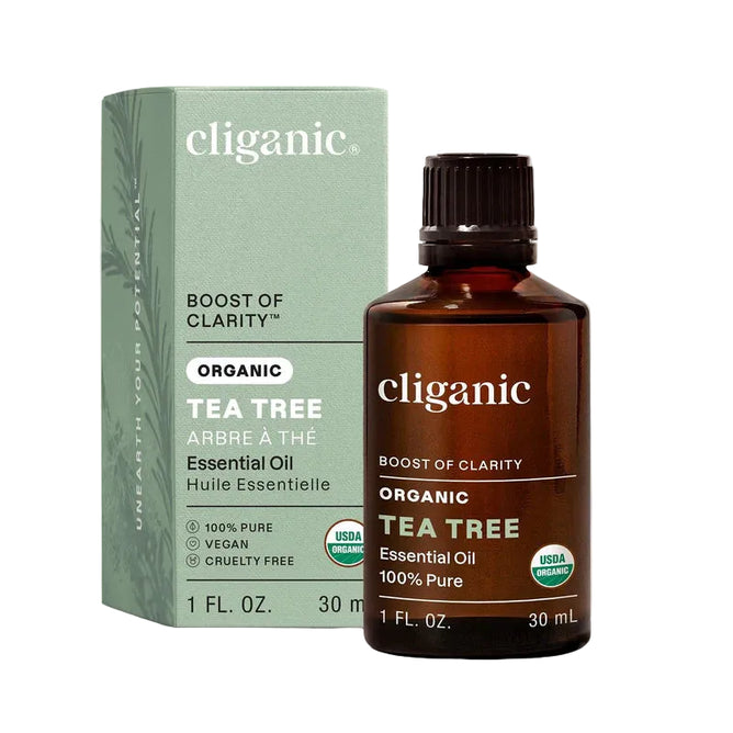 A bottle of Cliganic Organic Tea Tree Essential Oil – Boost of Clarity (30 ml) is shown beside its green box packaging, which features its purity, vegan, cruelty-free, and USDA organic certifications. This versatile essential oil can be used as a natural mosquito repellent or to soothe a dry scalp, making it a refreshing addition to your daily routine.