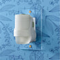 A Mrs. Meyer's Premium Scented Oil Diffuser Kit in white is plugged into a light blue wall patterned with line-drawn flowers and leaves, gently filling the space with refreshing garden-inspired fragrance.