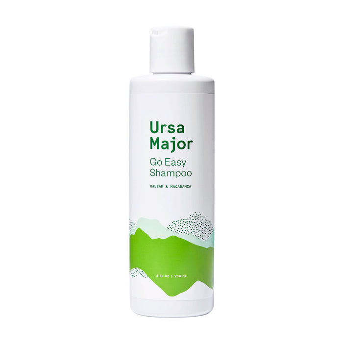 A white bottle of Ursa Major Go Easy Shampoo with green graphic mountains and text indicating it contains balsam and macadamia; the bottle holds 8 fl oz (236 mL).