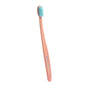 A pink toothbrush with blue bristles and COCO RUSH printed on the handle, shown against a plain white background.