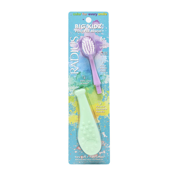 Radius Big Kidz Forever Brush toothbrush for ages 6+, shown in its packaging. The toothbrush has a wide, soft green handle and a purple brush head, with colorful splashes in the packaging background.