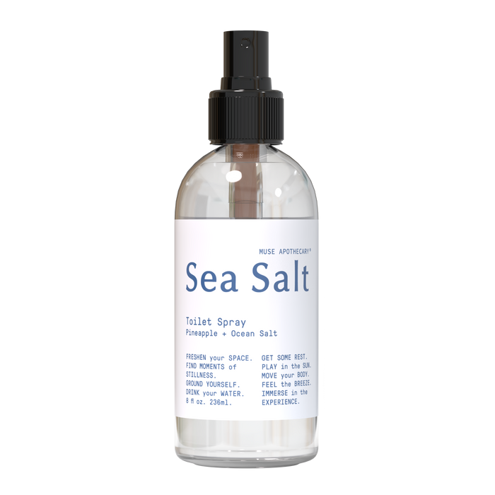 A clear spray bottle labeled Sea Salt Toilet Spray with pineapple and ocean salt scent by Muse Apothecary, containing 8 oz (238 ml). The bottle has a black spray nozzle and minimalist white label.