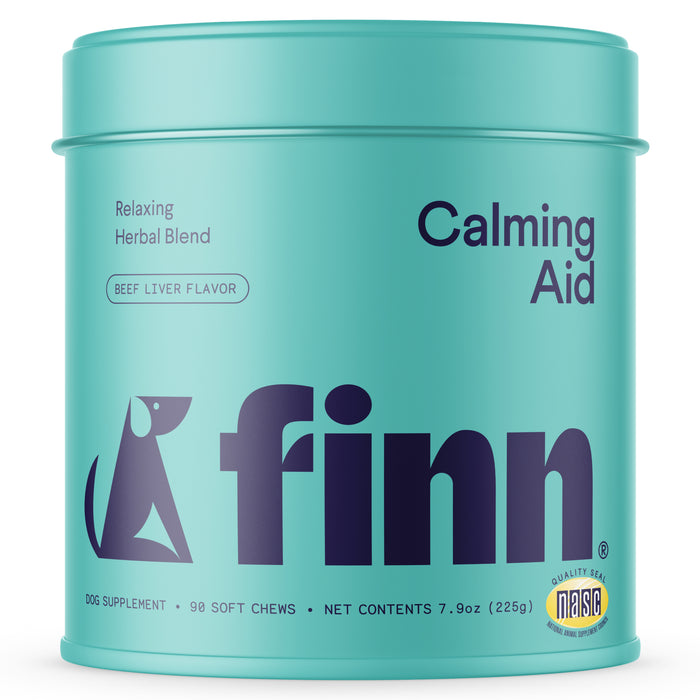 A turquoise container labeled finn Calming Aid, Relaxing Herbal Blend, Beef Liver Flavor. It holds 90 soft chews (dog supplement) and features a dog graphic with a Quality Seal NASC badge.