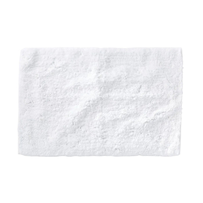 The Shag Organic Bath Rug by Coyuchi, a fluffy white rectangular bath mat made from organic cotton, is displayed on a plain white background, highlighting its soft and textured surface.