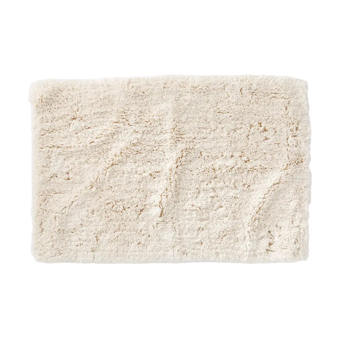 The Coyuchi Shag Organic Bath Rug features a plush, textured surface in a rectangular cream-colored design, perfect for adding cozy comfort to your bathroom floor.