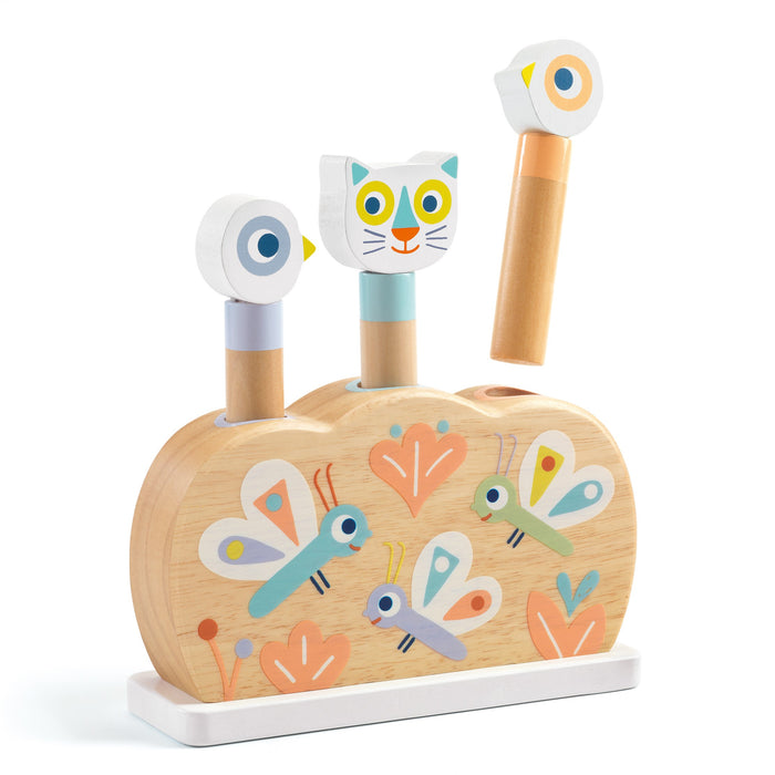 A wooden toy with three animal pegs (two birds and a cat) that pop up, set in a decorated base featuring colorful butterflies and flowers on a light wood background.
