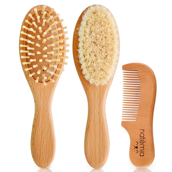 Three wooden hair grooming tools: a brush with wooden bristles, a soft bristle brush, and a small wooden comb labeled natemia, all with smooth, light wood handles.