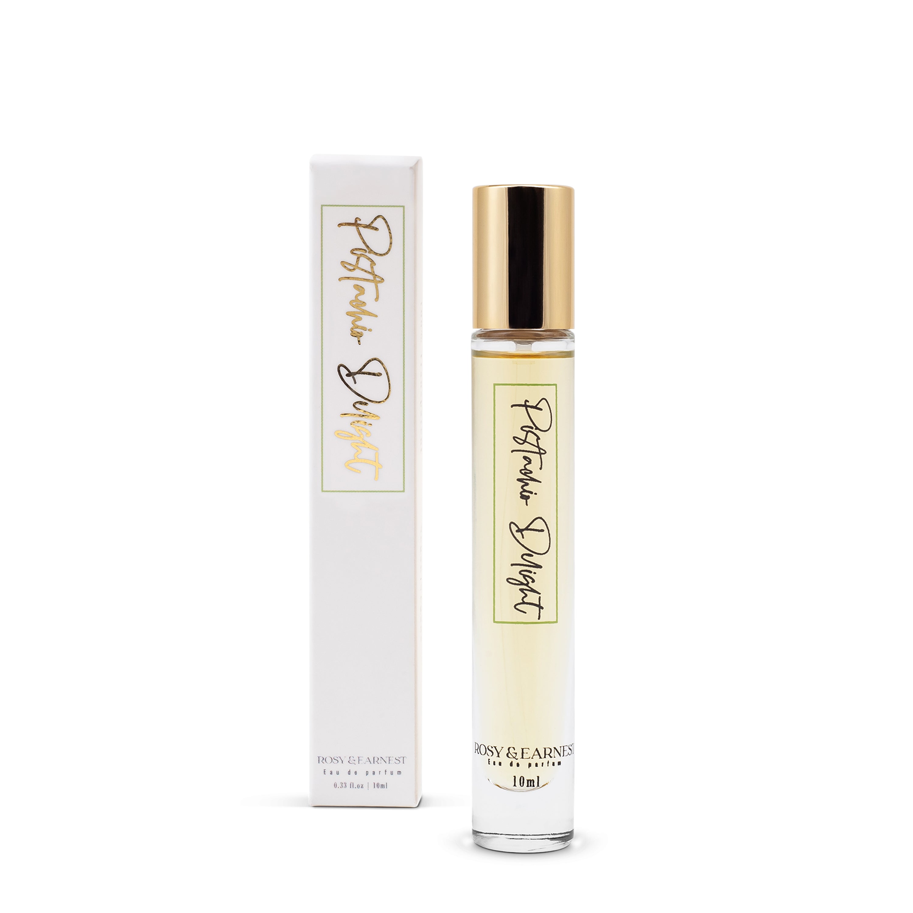 A 10ml bottle of Rosy & Earnests Pistachio Delight perfume with a gold cap sits next to its matching box, showcasing an elegant minimalist design. This EWG VERIFIED™ gourmand fragrance offers hints of pistachio among its refined branding and gold accents.