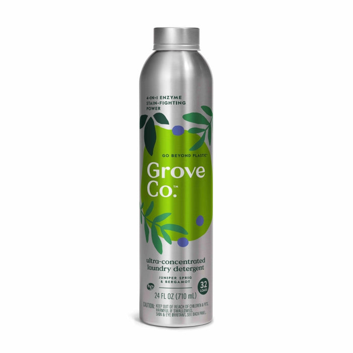 A silver aluminum bottle of Grove Co. ultra-concentrated laundry detergent featuring green leaves and dark blue berries on the label. The bottle holds 24 fl oz and highlights enzyme stain-fighting power.