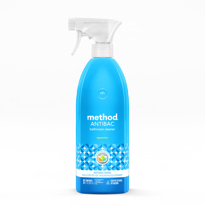 A blue spray bottle of Method Antibac bathroom cleaner in spearmint scent, featuring geometric patterns and a white spray nozzle, displayed against a plain white background.