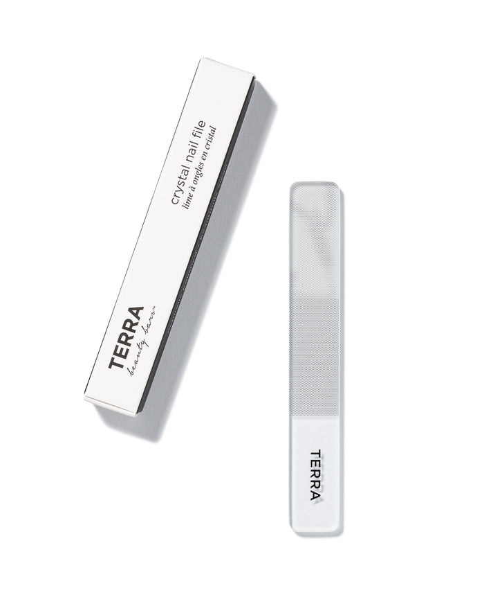 A clear crystal nail file with a white handle labeled TERRA, shown next to its white and black box packaging labeled TERRA beauty bars crystal nail file.