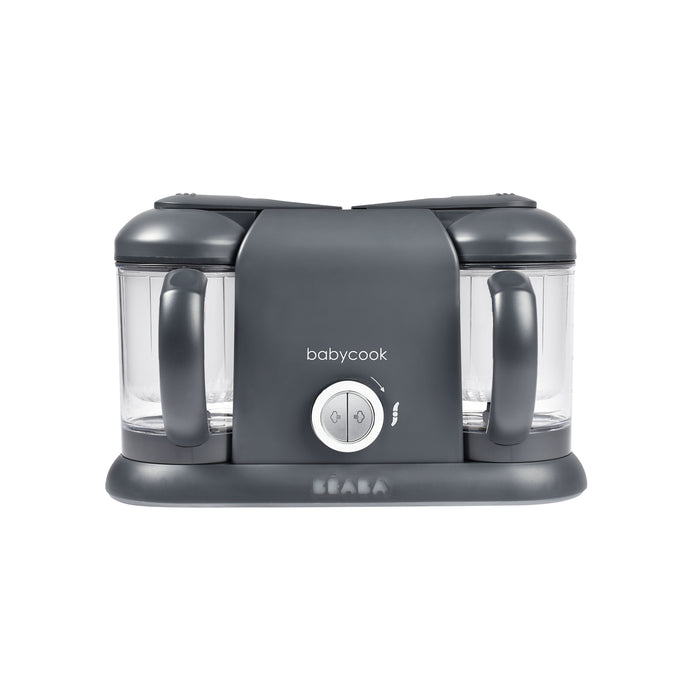 A gray BEABA Babycook food maker with two clear blending containers, two handles, and a central control knob, shown against a white background.