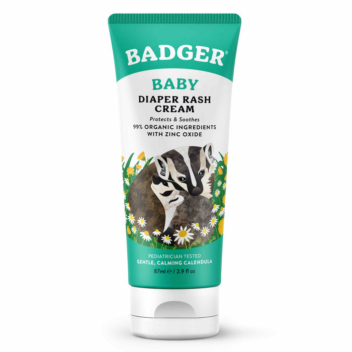 A tube of Badger Baby Diaper Rash Cream featuring illustrations of two badgers surrounded by flowers. The label highlights 99% organic ingredients, zinc oxide, and a gentle, calming formula. The tube size is 87 ml (2.9 oz).