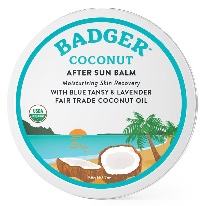 Round tin of Badger Coconut After Sun Balm, featuring an illustration of a beach, palm tree, and split coconut. Text highlights moisturizing, organic, and fair trade ingredients with blue tansy and lavender.