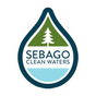 Logo for Sebago Clean Waters featuring a blue water droplet shape containing a green section with a white pine tree, and the words “Sebago Clean Waters” in blue text below the tree.