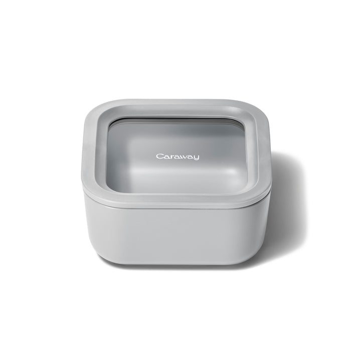 A square, light gray food storage container with a transparent lid, labeled Caraway, is shown on a white background.